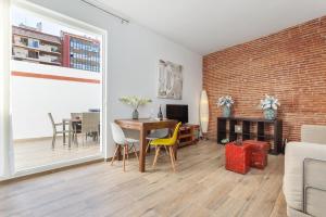 a living room with a table and chairs and a brick wall at Matarolux 7 in Mataró