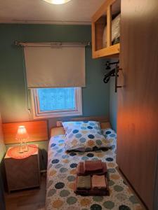 ein kleines Schlafzimmer mit einem Bett und einem Fenster in der Unterkunft Lolasurmer in Bredene
