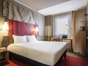 a hotel room with a large white bed and a window at ibis Sens in Sens +109 photos