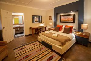 a bedroom with a large bed and a bathroom at Hadassa Guest House in Otjiwarongo