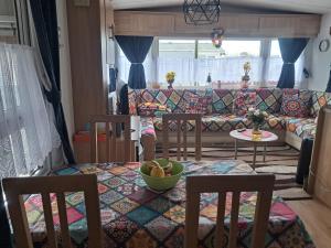 ein Wohnzimmer mit Tisch, Stühlen und Sofa in der Unterkunft Lolasurmer in Bredene