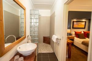 a bathroom with a sink and a bedroom with a bed at Hadassa Guest House in Otjiwarongo
