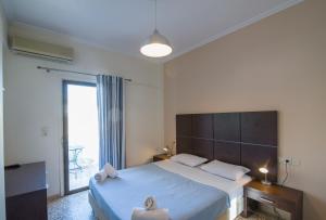 a bedroom with a large bed with a large window at Kamari Blue Boutique Hotel in Kamari