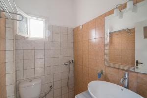 a bathroom with a toilet and a sink and a window at Kamari Blue Boutique Hotel in Kamari +16 photos
