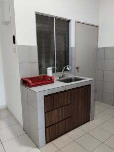 a small kitchen with a sink and a mirror at IJM Suria Homestay in Sandakan