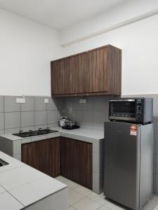 a kitchen with wooden cabinets and a stainless steel refrigerator at IJM Suria Homestay in Sandakan
