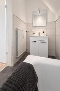 a white bathroom with a bed and a sink at Modernes Apartment 3 in Bad Kreuznach mit einfachem 24h Self-Check-in in Bad Kreuznach