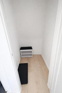 a small white room with a black stool in the corner at Modernes Apartment 3 in Bad Kreuznach mit einfachem 24h Self-Check-in in Bad Kreuznach
