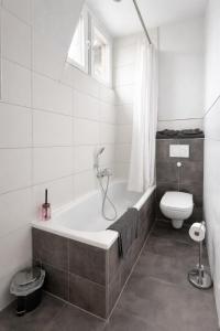 a bathroom with a bath tub and a toilet at Modernes Apartment 3 in Bad Kreuznach mit einfachem 24h Self-Check-in in Bad Kreuznach