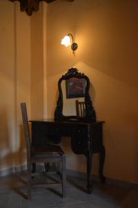 Guesthouse Rodamos في تاكسيارشيس: وجود مرآة على رأس مكتب مع كرسي