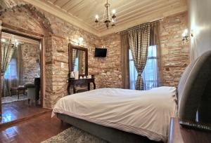 a bedroom with a bed and a stone wall at Archontiko in Andritsaina