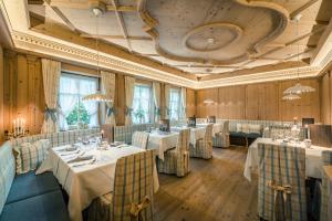a restaurant with tables and chairs in a room at Hotel Maria in Ortisei