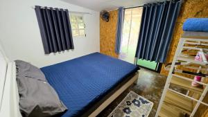 a bedroom with a bed with blue sheets and windows at Hostel Ko Kut in Ko Kood