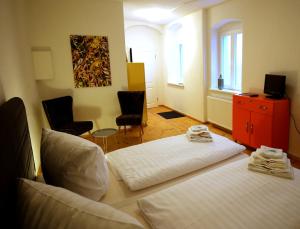 a room with a bed and two chairs in it at Stadtvilla Rosengasse 7 in Meißen