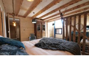 a bedroom with a bed with a black blanket on it at Forest d' ARTO in Ancelle