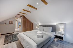 a bedroom with a large white bed and a staircase at Forest House Premium Breaza in Breaza de Sus