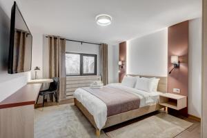 a hotel room with a bed and a desk at Forest House Premium Breaza in Breaza de Sus