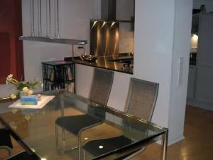 a glass table with two chairs and a kitchen at Zum oberen Schulhof in Konstanz