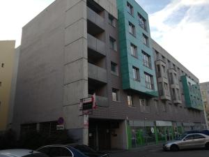 a tall building with a car parked in front of it at Apartamenty Sedinum - Modern in Szczecin