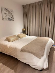 a bedroom with a large white bed and a window at Spacious and modern apartment with open sea view in Ostend +56 photos