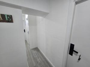 a hallway with a white wall and a white door at Blue Studio - Cozinha Privativa - Eficacia Living Abrantes in Abrantes