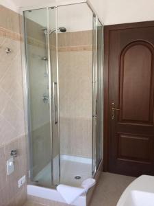 y baño con ducha y puerta de cristal. en Apartment Flat Fiumicino, en Fiumicino