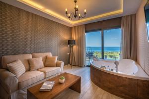 een woonkamer met een groot bad en een bank bij Elegance Luxury Executive Suites - Adults Only in Tragaki