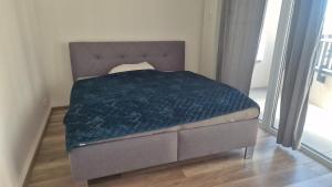 a bed in a room with a blue blanket on it at 3-room apartment in Trnava