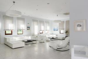 uma sala de estar branca com sofás e cadeiras brancos em La Mer Deluxe Hotel & Spa em Kamari