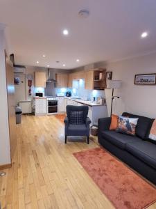 ein Wohnzimmer mit Sofa und eine Küche in der Unterkunft Orkneyinga in Kirkwall