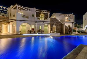 a swimming pool in front of a house at night at La Mer Deluxe Hotel & Spa in Kamari