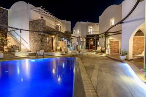a pool in front of a house at night at La Mer Deluxe Hotel & Spa in Kamari