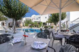 restauracja ze stołami i krzesłami oraz basen w obiekcie La Mer Deluxe Hotel & Spa w mieście Kamari