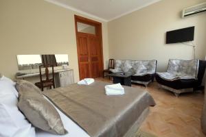 a bedroom with a bed and chairs and a television at Georgian House in Tbilisi City