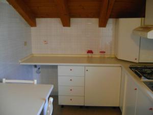 a kitchen with white cabinets and a counter top at La Maison Nouva 1977 in Aosta