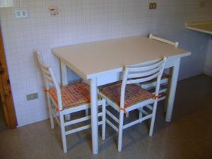 a table and two chairs sitting next to a kitchen at La Maison Nouva 1977 in Aosta +13 photos
