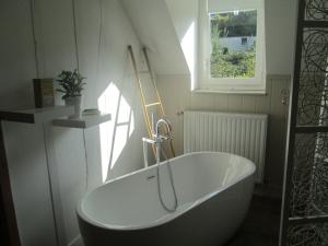 a white bath tub in a bathroom with a window at Chambres d'hôtes Atypik in Dieppe
