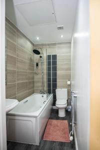 a bathroom with a white tub and a toilet at The Way House in Manchester +49 photos