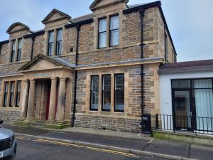 ein altes Backsteingebäude am Straßenrand in der Unterkunft Orkneyinga in Kirkwall