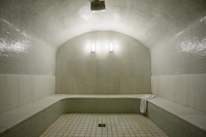 a bathroom with a bath tub with a tile floor at La Mer Deluxe Hotel & Spa in Kamari