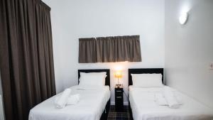 two twin beds in a room with a window at The Way House in Manchester