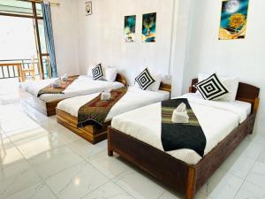 two beds in a room with white walls at Nongkhaiw Hostel in Nongkhiaw
