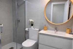 a bathroom with a toilet and a sink and a mirror at NUEVO-LUZ DE CONIL piscina y parking in Conil de la Frontera +22 photos