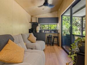 a living room with a couch and a kitchen at Crown Equine Retreat in North Dandalup