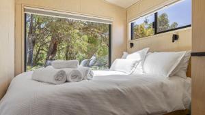 a bedroom with a white bed with a large window at Crown Equine Retreat in North Dandalup