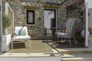 a patio with two chairs and a table at La Mer Deluxe Hotel & Spa in Kamari