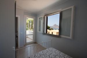 マカリにあるUn mare di Blu - Casa Cobaltoの窓2つ、景色を望むベッド1台が備わる客室です。