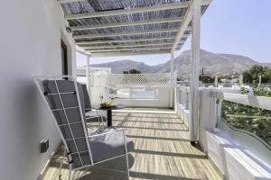 a balcony with a pergola and a table at La Mer Deluxe Hotel & Spa in Kamari