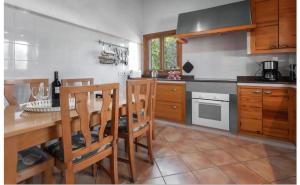 a kitchen with a wooden table with chairs and a counter at Sa Torreta in Algaida