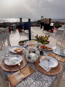 a table with plates of food on a patio at Regina Margherita B&B in Marzamemi